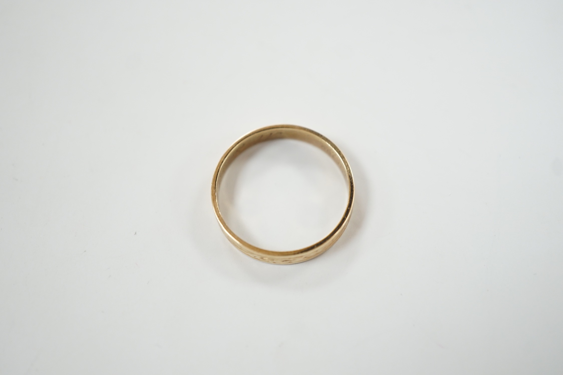 An engraved 9ct gold wedding band, size P, 2.1 grams.